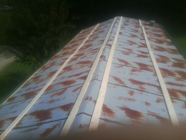 Rusted metal roof panels with new wood purlins before replacement — Storm Damage Roof Repair in Devine by Roofing Brothers