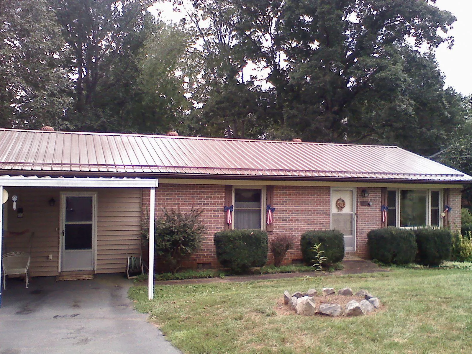 Bronze metal roof and carport on a brick ranch home — Roof Repair work by our crew in Devine